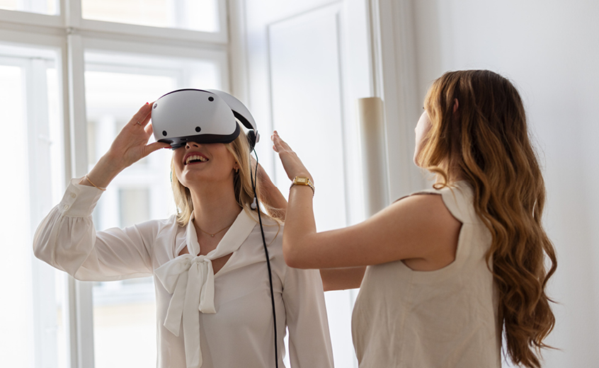 Zwei Frauen im Workshop mit Virtual-Reality-Brille: Eine Teilnehmerin testet eine VR-Brille, während eine andere Frau unterstützend an ihrer Seite steht.